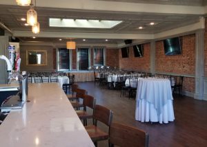 Upstairs Private Party Room showing Bar, Large LCD TVs, and Tables.